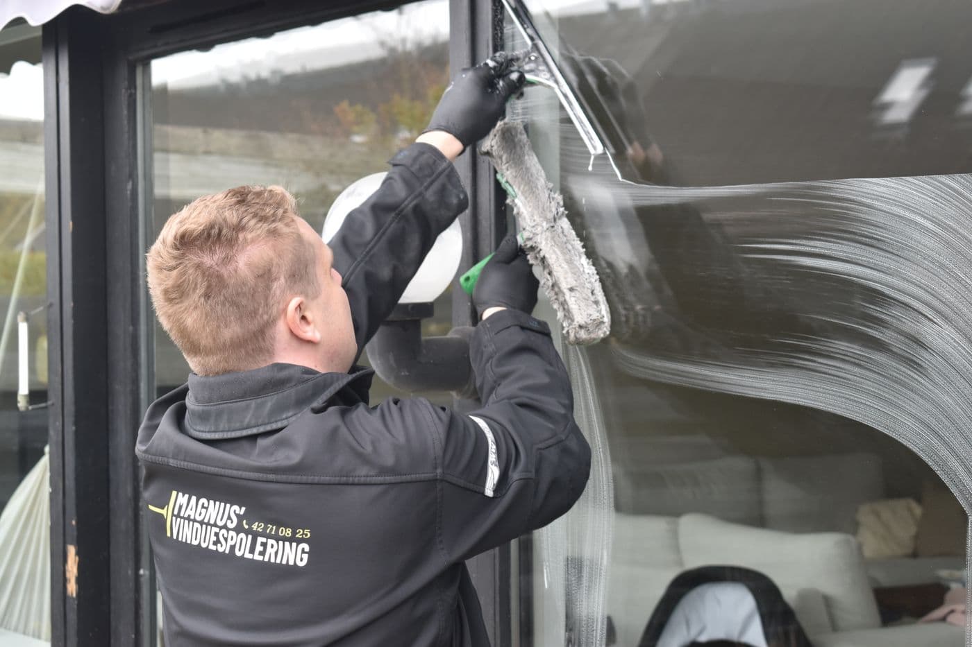 A window cleaner working with a squeegee